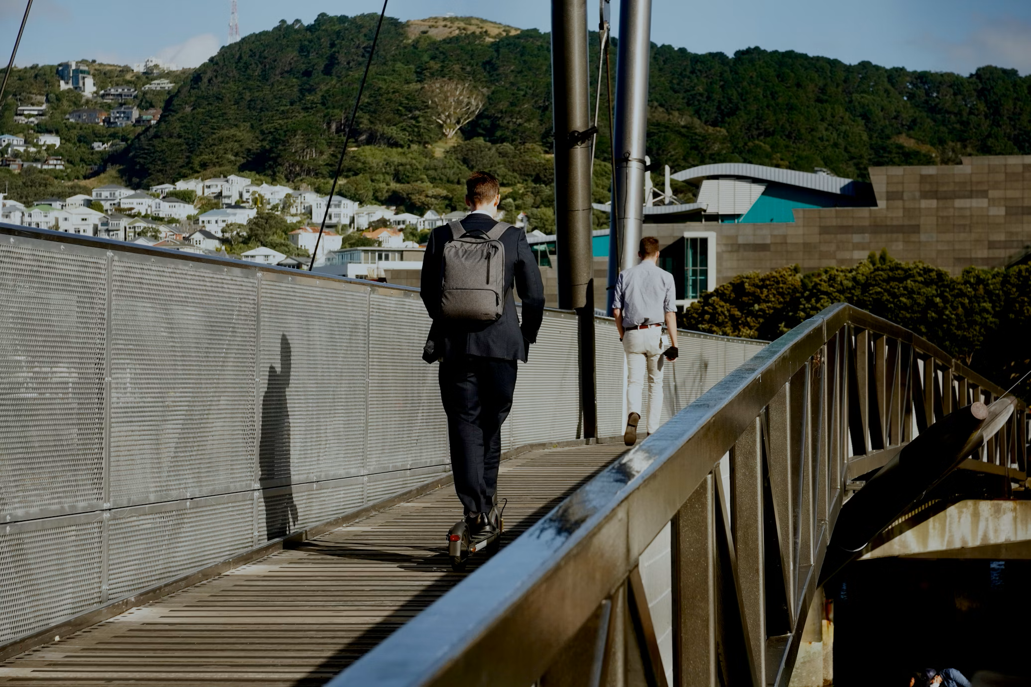 One man scoots and one man walks across the Whairepo Lagoon bridge on the Wellington waterfront